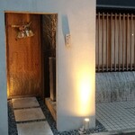 馳走 啐啄一十  - 店舗外観
      落ち着いた雰囲気
      槍鉋で削り出された扉がライトに照らされ陰影を浮かび上がらせています。