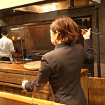 アカ - ソムリエの西谷さんがベネンシアを使ってワイングラスにシェリーを注ぎます