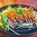 フェニックス - ステーキ！上にナッツ状のガーリック？下にはもやし野菜たっぷり！パクチー？の色のアクセントが良い！