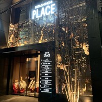 ぬま田 - 前を歩く人が立ち止まって見上げる新築ビル