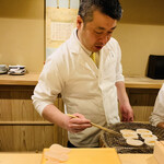 富小路 やま岸 - ☆山岸大将が炭火で平貝に醤油を塗って焼いていく。