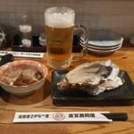 北海道さかな一途 直営魚問屋 - 生ビールとお通しの煮ツブとクーポン提示の無料生牡蠣