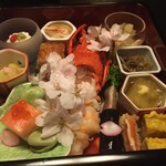 三養荘 - 一の重。桜の花が彩る。花の下にも料理が多数