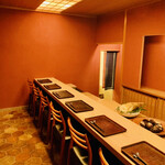 緒方 - ◎朱色の壁に竹の節であしらわれた天井と栂のカウンターが店内に映える。