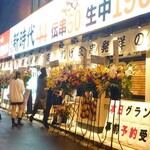 Shinjidai Yonyon - 開店祝いの花がずらりと並ぶ店頭