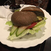 魔愁 - 料理写真:ハンバーグサンド→バンズは黒胡麻？を混ぜ込んだバンズを使用。トマトや胡瓜、レタスなどはかなりたっぷり目。そしてハンバーグはかなり肉感がしっかりとした逸品。