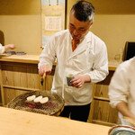 富小路 やま岸 - ◎平貝を炭火で焼いていく山岸さん。笑顔を絶やさない。