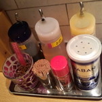 麺屋一燈 - 卓上にはｺｼｮｳ、ﾗｰ油、酢、一味があり、ｶｳﾝﾀｰ上段には「割りｽｰﾌﾟ」のﾎﾟｯﾄ有