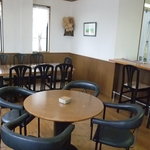 花風林 - 1Fの様子、手前にも丸テーブルが2つ、壁面には井出孝さんの水彩画がさりげなく飾られています。