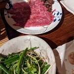 炭火焼肉 七厘亭 - ネギとかいわれを巻いて食べるロース