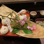 研覃 ほりべ - 金の竹皮の上に巻物の器と桜をのせた八寸