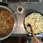 紀ノ国屋 - 母の刻んだジャガイモを炒める姉、内径φ29cmの特大鍋を使う。