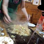 お好み焼き 福竹 - 両手のヘラで、ジャンジャカと手早く混ぜ合わせ、焼き上げる。