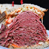 Sarge’s Delicatessen & Diner - 料理写真:お店自慢にしてNY名物のパストラミサンドイッチ（店舗メニューより）。これは絶対にカードゲームしつつ片手で食べられるものではありませんね。
