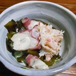 よし半 - お通し（タコ・カニ・ワカメ・キュウリの酢の物）