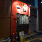 くいもんや 一歩 - 闇に浮かび上がる赤い壁、くいもんや「一歩」。中華料理をベースに、幅広い料理と日本酒を合わせる