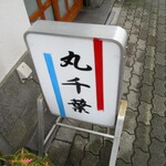 丸千葉 - 営業中を表すシンプルな立て看板。予約必須。