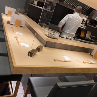 A relaxing space for adults with a beautiful white wood counter in a black-based store