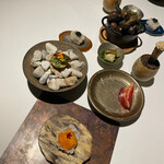 ラ・ヴァガボンド - 化石の上～アミューズ七種類　米粉チップスにのるチーズと北海道産ウニ　ハーブがのるチーズタルト　黒毛和牛の生ハムメロン　淡路島の鱧とキャビア　岐阜県産鮎のコンフィ　上に新生姜と中にサンマのマリネが忍ぶコルネ　赤座海老と伏見甘長唐辛子のベニエ