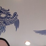 中華料理 鳳凰 - 伝説の鳥獣、鳳凰が羽ばたいております。しかも2頭です。縁起が良いですね。左下に写り込んでしまったのはわたしのキャップの鍔（つば）です。