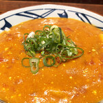 丸亀製麺 - オレンジ色のカレールーの中には溶き卵とトマトが顔を覗かせております。