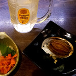 釧路食堂 - 左：飲み放題用お通し ホヤの塩辛　右：びっくりお通し あわびの煮付け丸ごと1個