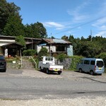 わたりや - これは食べ終わった後、停めておいた原付スクーターからお店を望んだスナップです。原付スクーターの駐車場から道を挟んで向こう側の駐車場に3台停まってます。その向こうに見えるのがお店です。