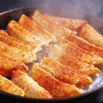 Izakayakomakura - 屋台から生まれた『博多鉄鍋餃子』！熱々の鉄鍋でかりっと仕上げた餃子は肉汁が溢れる！新定番料理