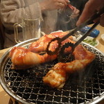 西日暮里 ホルモン - 「牛小腸１本つぼ漬け」です。手はスタッフ