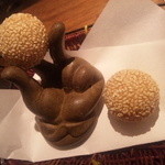 黒猫夜 - 怪しい手の置物にのった胡麻団子