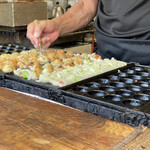 たこ焼まるちゃん - 大将がリズミカルな動きでたこ焼きをひっくり返す大将はテクニシャン！