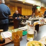 かしら屋 - カウンター席は焼き場と厨房を囲む形になっている