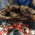 炭火焼肉 寿月 - ちょっとよく分からない。状態ですが、骨付きカルビの肉をハサミでカットした後、骨の上で休ませています（＾ν＾）