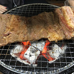 炭火焼肉 寿月 - 骨付きカルビの焼き始めですね。やはり、炭火のパワーで素早く焼き上がります。