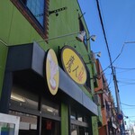 魔人豚 - 壁の緑と看板の黄色