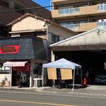 タンタン - 店舗の右側ガレージに、駐車スペースがあり、その車の周りに入店待ちの客が列を作っている。