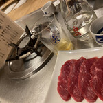 桜なべ　みの家 本店 - 美しいステンレスのテーブルに馬刺しの赤。