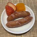 ホットケーキ つるばみ舎 - 珍しく塩っぽいものを身体が欲してて、ポークウィンナー250円をトッピング。切れ目に愛を感じる。美味しい。そして、おまけのフルーツが嬉しい。苺、甘い！みかんはふつう。（ミカン、あんまり好きではない。