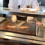 ダイニング ブリックサイド - 鉄板で牛肉を焼いている