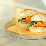 ICOR NISEKO - 【ニセコ野菜のサンドイッチ】当店の定番サンドイッチ。お肉は使わず、ニセコ産の新鮮な野菜で作ったヘルシーなベジタブルサンドイッチ。シャキシャキとした鮮度満点の野菜のうまみを、存分に感じていただけるサンドイッチです。バンズはニセコ本店の近くに店舗をかまえる「奥土農場」の石窯と薪で焼いたパン。ニセコの恵みと美味しさを堪能してください。