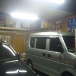 店の入り口には車が、その奥に縄のれん