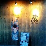 おいしんぼう蔵 - 店舗入口の壁の店名ロゴ