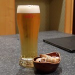 ふぐ屋とら乃介 - 生ビールと付きだしのバイ貝の旨煮