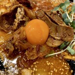 味噌乃マルショウ - 甘めの味付けの豚バラ肉がトッピングされていて、その上に生卵の黄身をのせます