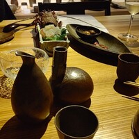 眞か SHINKA - お酒三種頼んだら、徳利が三種。
                辛口のデラウェアワイン、伊勢海老の刺身、ベーコンと鶉玉子の燻製