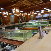 稚加榮 本店 - 大きな生簀を囲むカウンター席とその回りの小上がり
