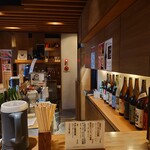 なかむら - カウンター内には日本酒の瓶が並んでいます。