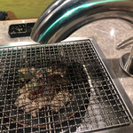 炭火焼肉と炉端 康 - テーブルの焼き場。煙の吸気ダクトは床下に伸びています。このダクトは、炭火焼肉店では新スタイルですね。