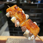 YAKITORI 燃 es - 現在不動の四番バッター！バリバリの皮の食感と挟んだ腿の肉汁を禰宜が吸収して旨味が一気に溢れだす、おかわり必死の一本です！