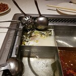 海底撈火鍋 - 白湯スープへ豚骨を投入(あっと言う間に入れてしまう！